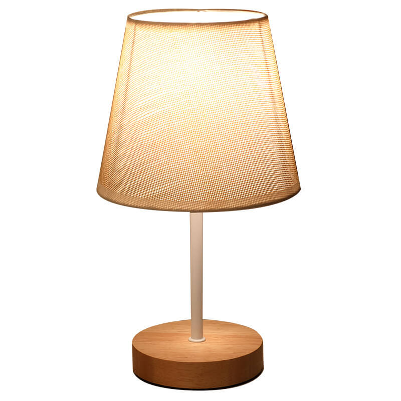 Table lamp with a wooden base and beige fabric shade on a white background