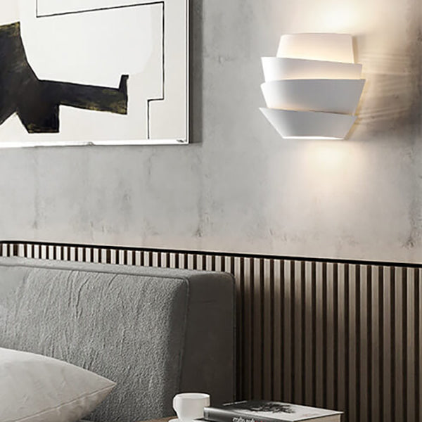 Modern interior design with a gray sofa, abstract painting, and wall-mounted light fixture.