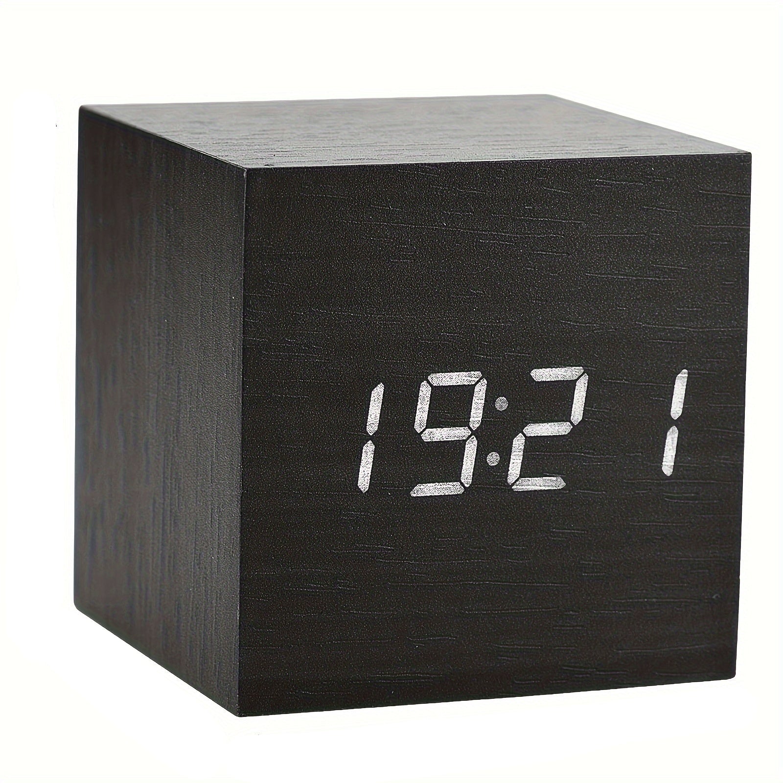 Black cube-shaped digital clock with LED display on a white background