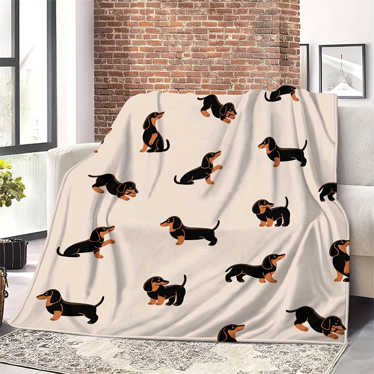 Blanket with dachshund pattern draped over a couch in a living room.