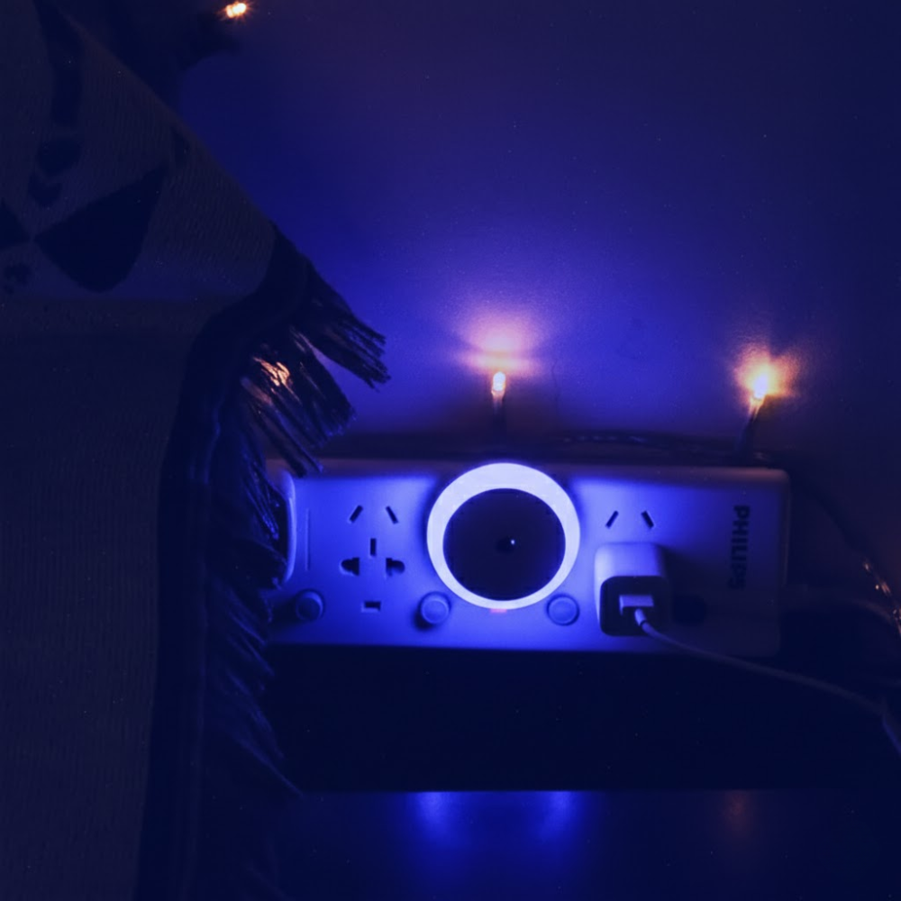 Person holding a Philips device with blue lighting in a dark setting