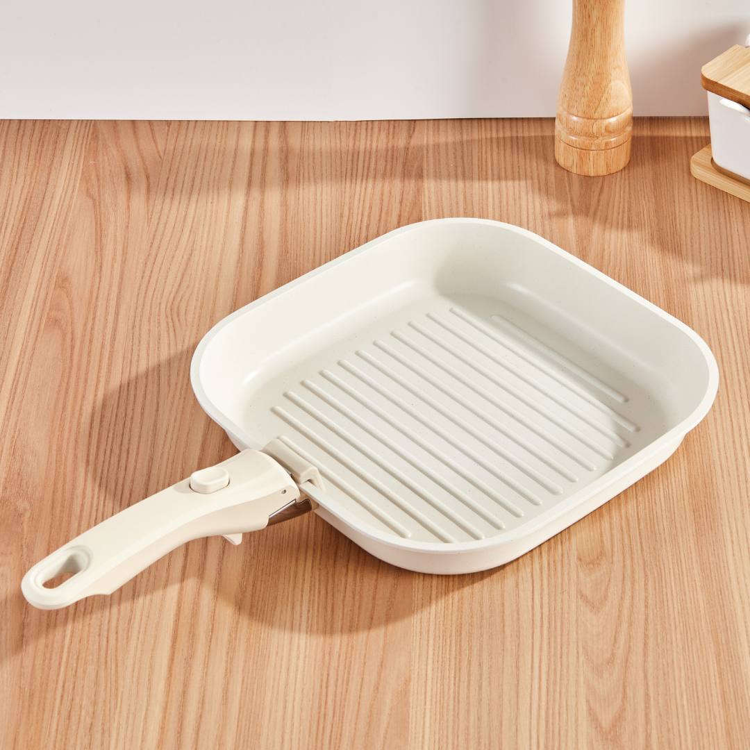 White grill pan with handle on a wooden surface