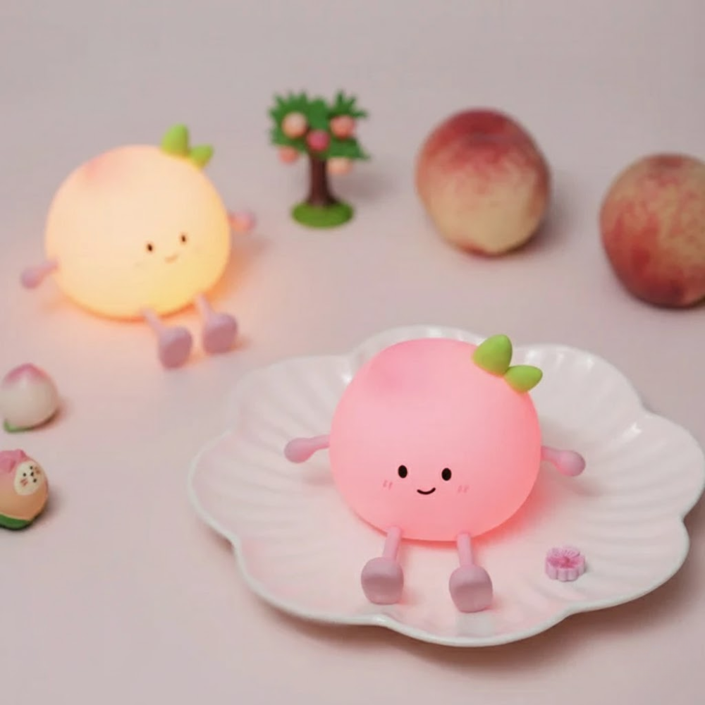 Cute peach-shaped night light on a shell with other similar night lights in the background.