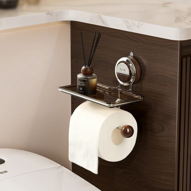 Toilet paper holder with a diffuser and candle on a wooden shelf.