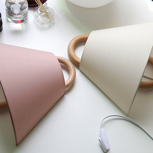 Two cylindrical lamps with wooden handles on a white surface.