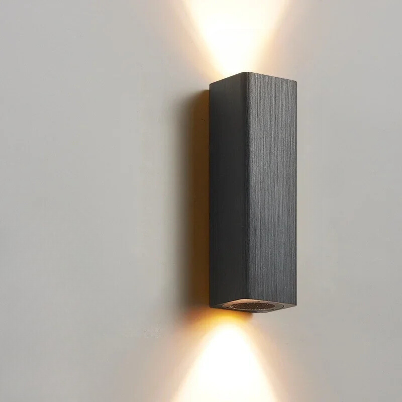 Black rectangular wall light fixture on a gray wall