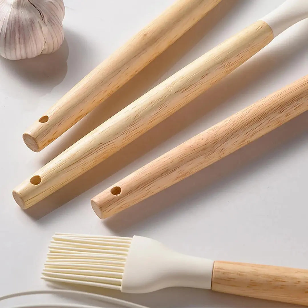 Three wooden cooking brushes with silicone bristles on a light background