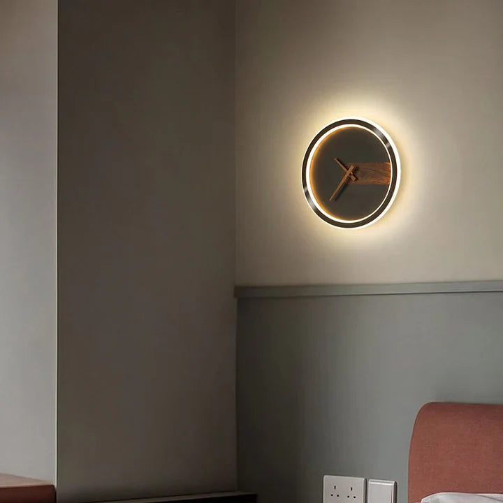Wall-mounted clock with a glowing rim on a neutral wall.