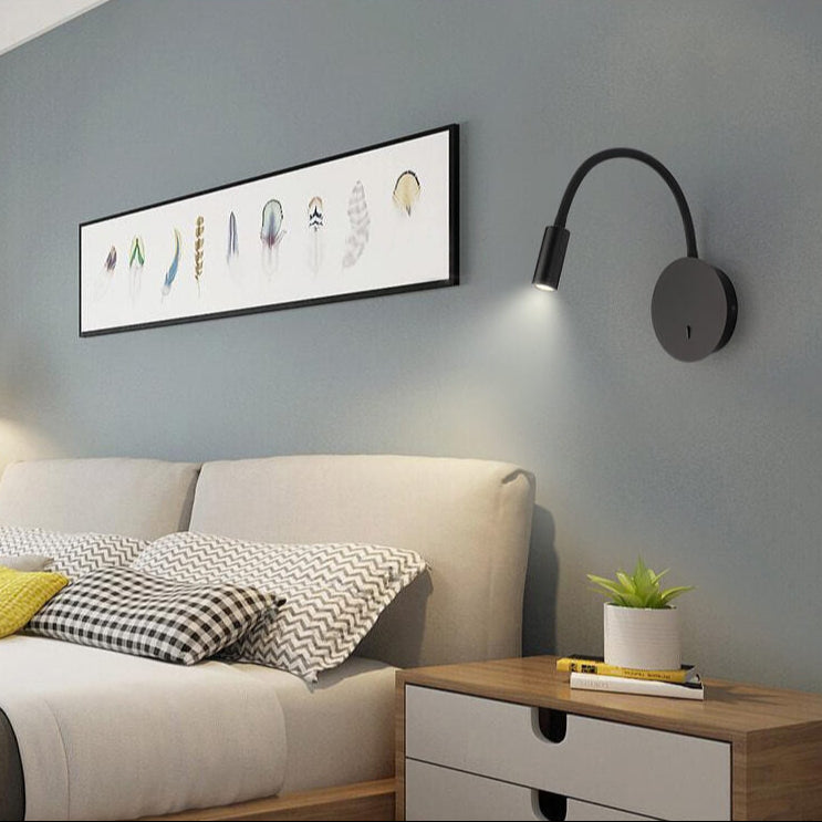 Modern bedroom with bed, nightstand, wall lamp, and decorative elements.
