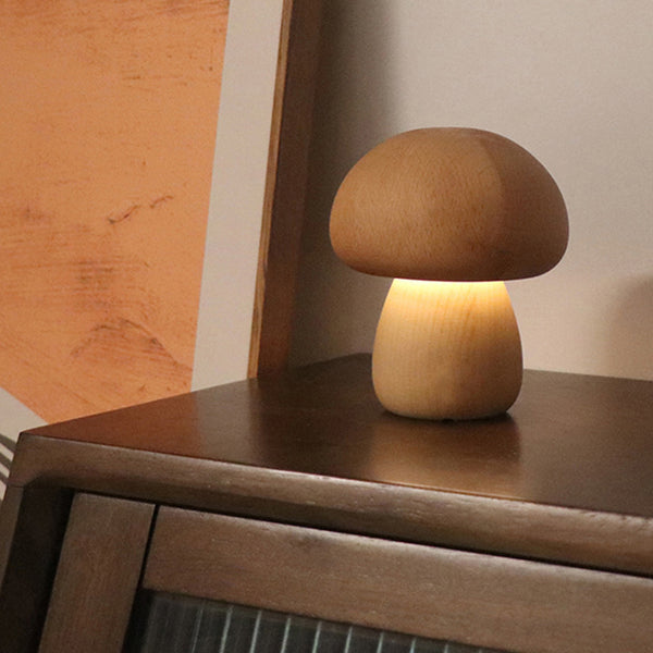 Wooden mushroom-shaped lamp on a wooden surface with a warm glow.
