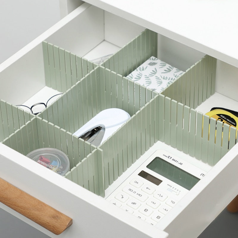 Desk organizer with compartments holding office supplies on a white desk.