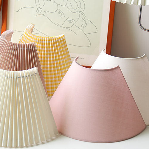 Colorful lampshades on a white surface with a light background