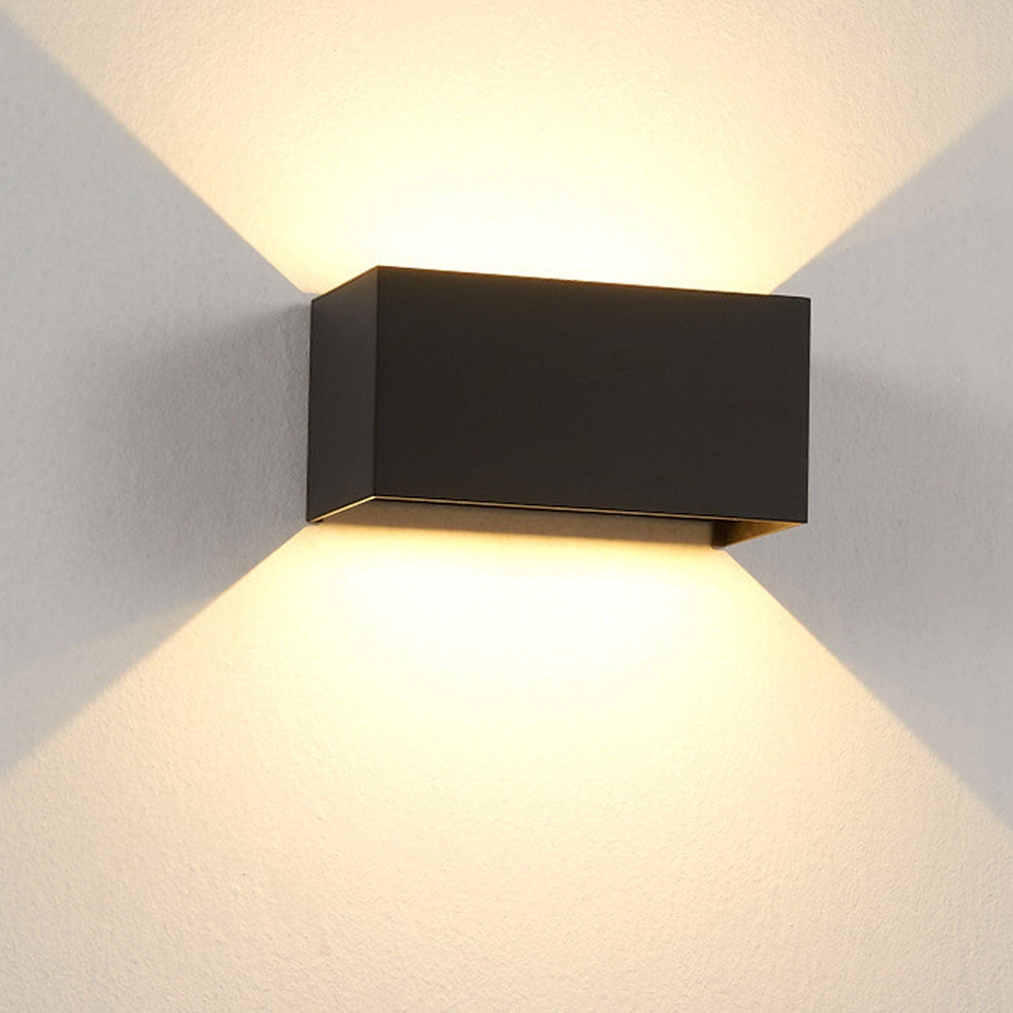 Modern black wall-mounted light fixture on a gray wall