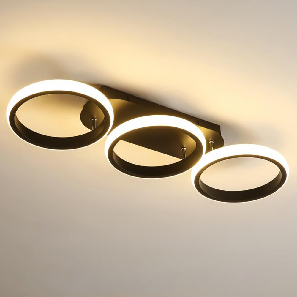 Modern ceiling light fixture with three circular rings on a plain background