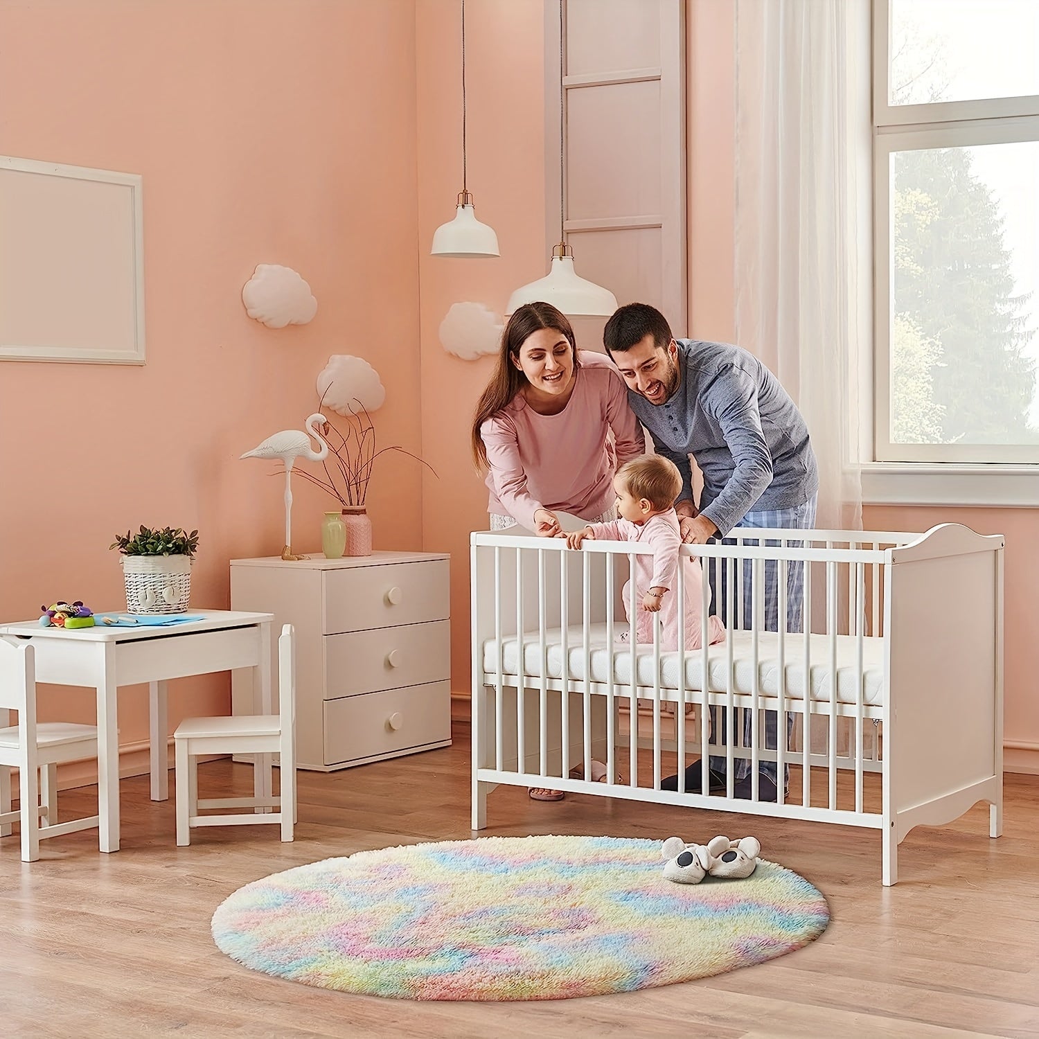 Family in a nursery with a white crib and pastel decor