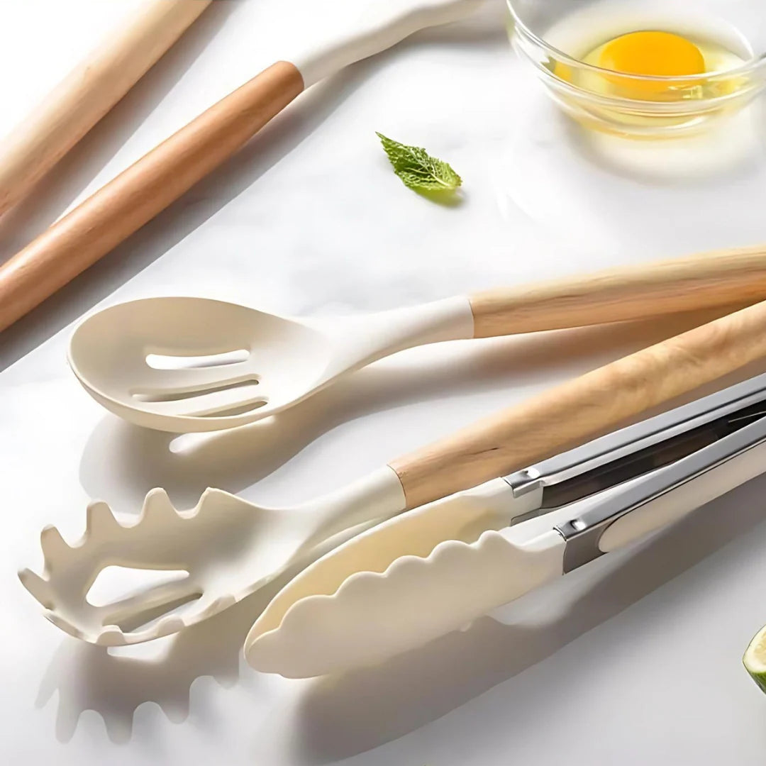Set of kitchen utensils with wooden handles on a white surface.