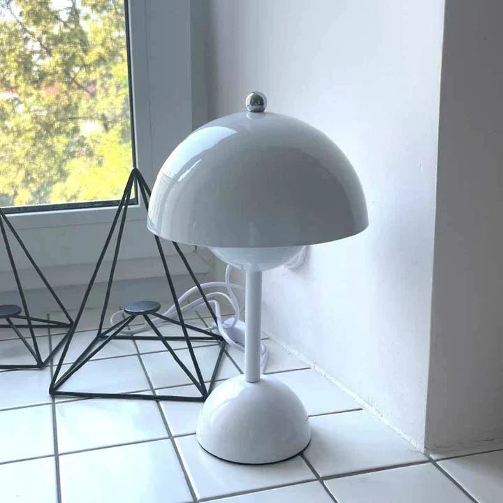 White table lamp on a tiled floor with a window in the background