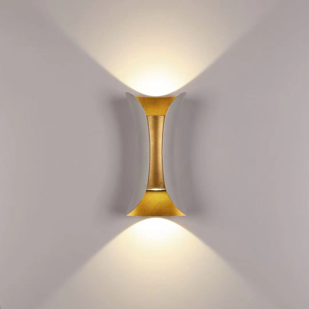 Gold wall-mounted light fixture on a gray background