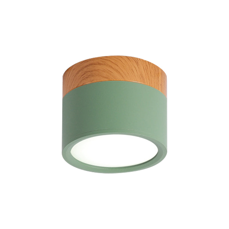 Ceiling light fixture with wooden top and green base on a white background
