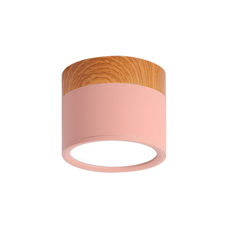 Ceiling light fixture with wooden top and pink base on a white background