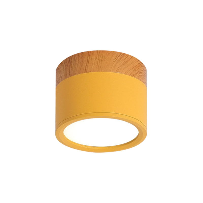 Ceiling light fixture with yellow shade and wooden top on a white background