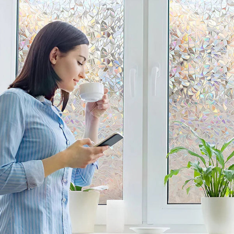 Woman holding a cup and phone in front of a decorative glass window