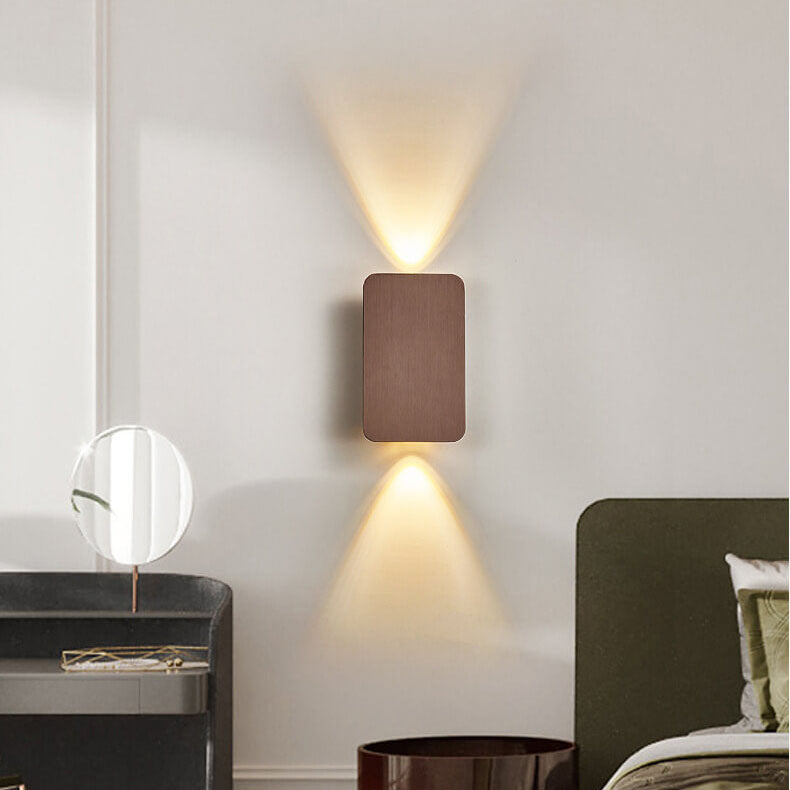 Modern wall-mounted light fixture on a neutral wall in a room with minimal decor.