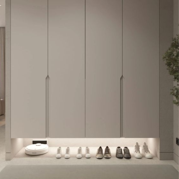 Row of shoes lined up against a wall with cabinets in a modern interior setting.
