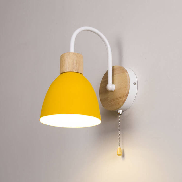 Wall lamp with yellow shade and wooden base on a gray background