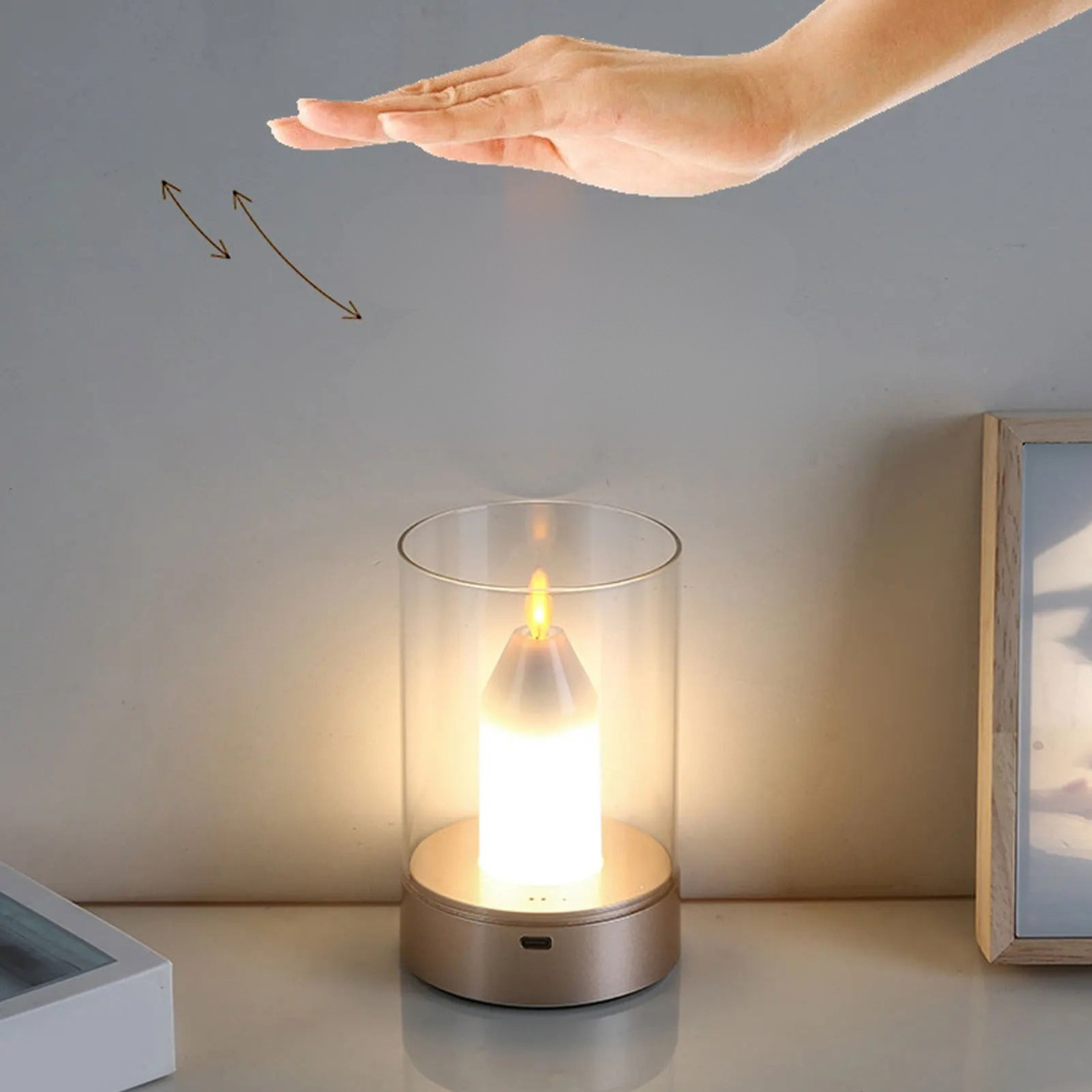 Hand reaching towards a small candle-like lamp on a table with a neutral background