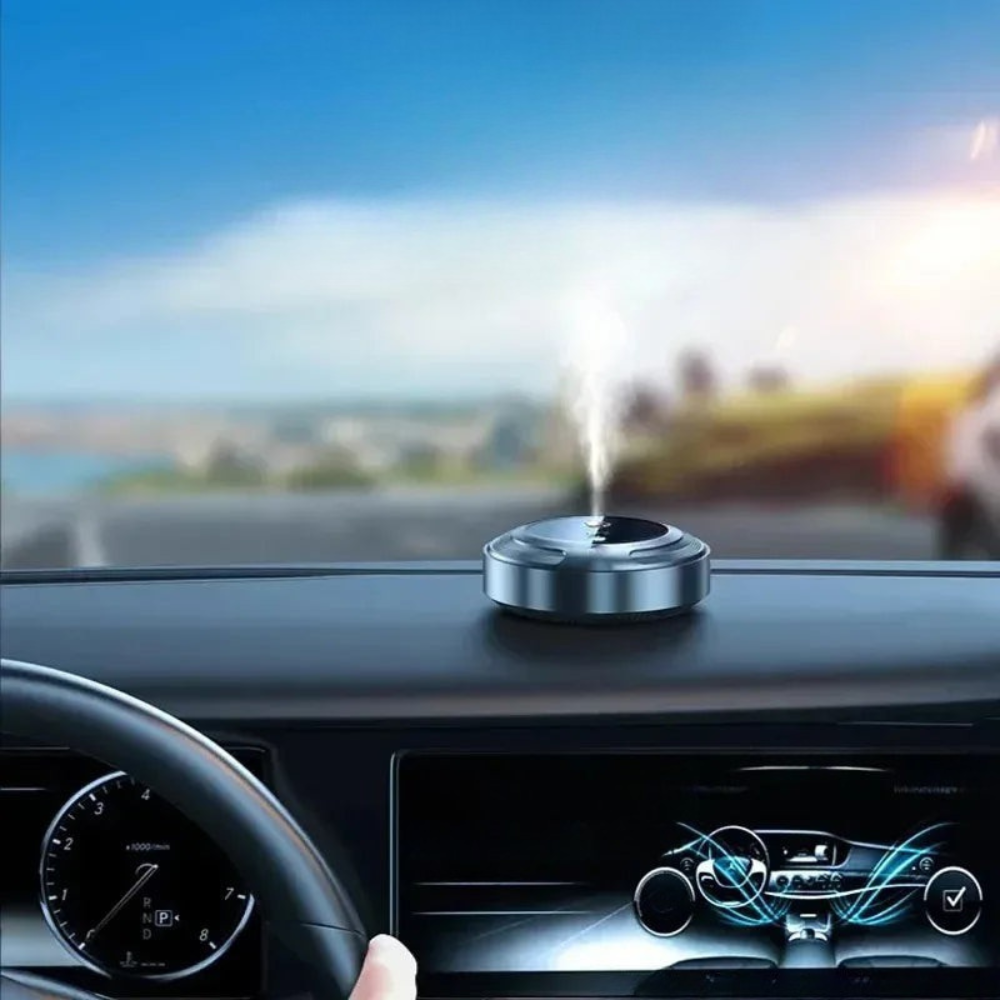 Car air freshener on a dashboard with a scenic road in the background