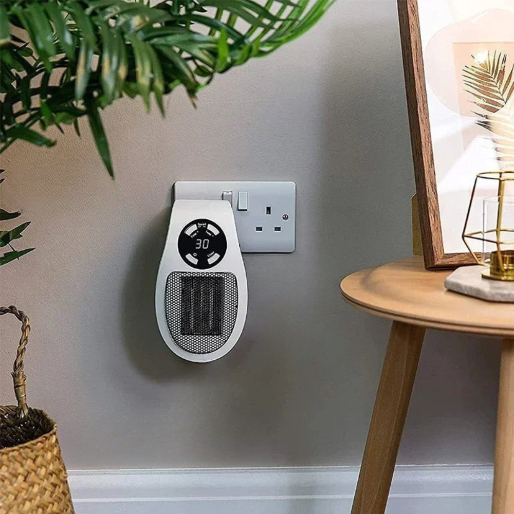 Wall-mounted space heater with digital display next to a power outlet on a gray wall.