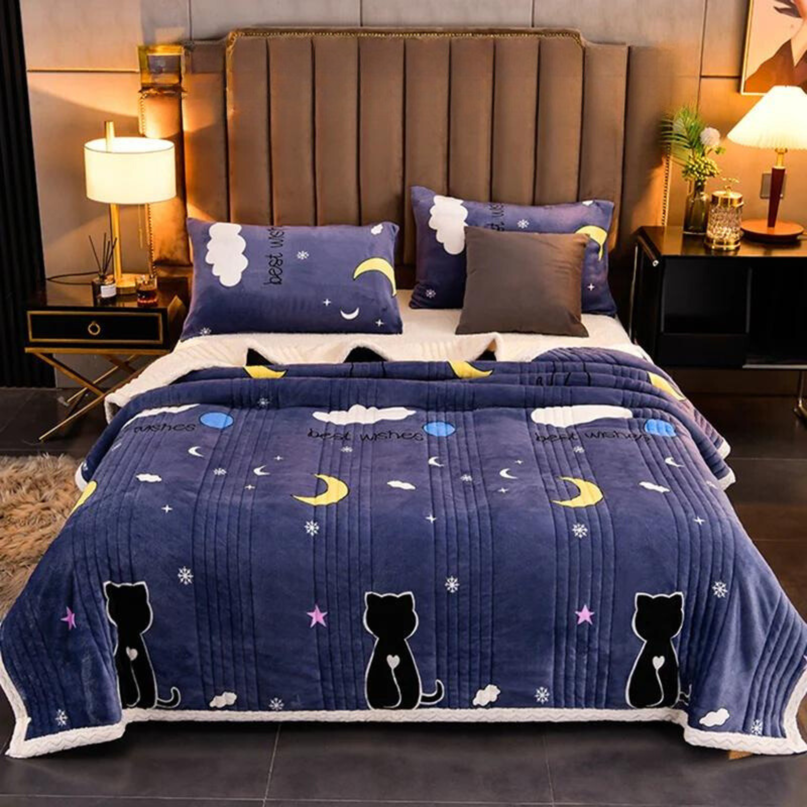 Bed with blue quilt featuring cat and moon designs, surrounded by a cozy bedroom setting.