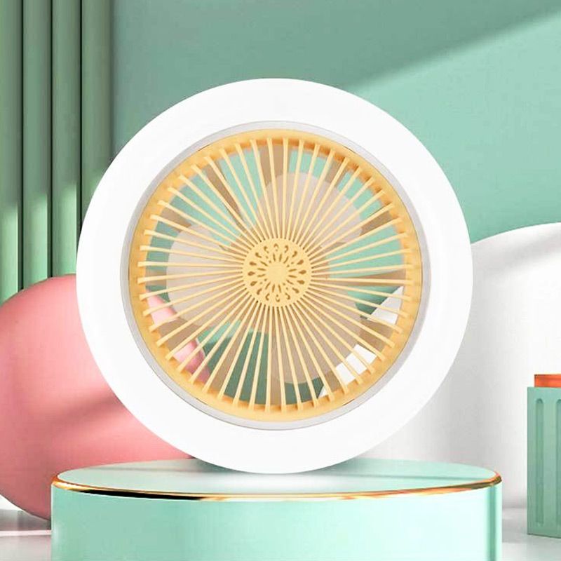 Round fan with white frame and yellow center on a green platform against a light green background