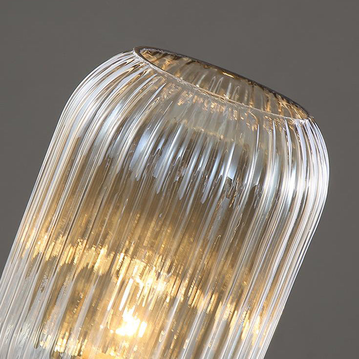 Close-up of a ribbed glass pendant light against a dark background