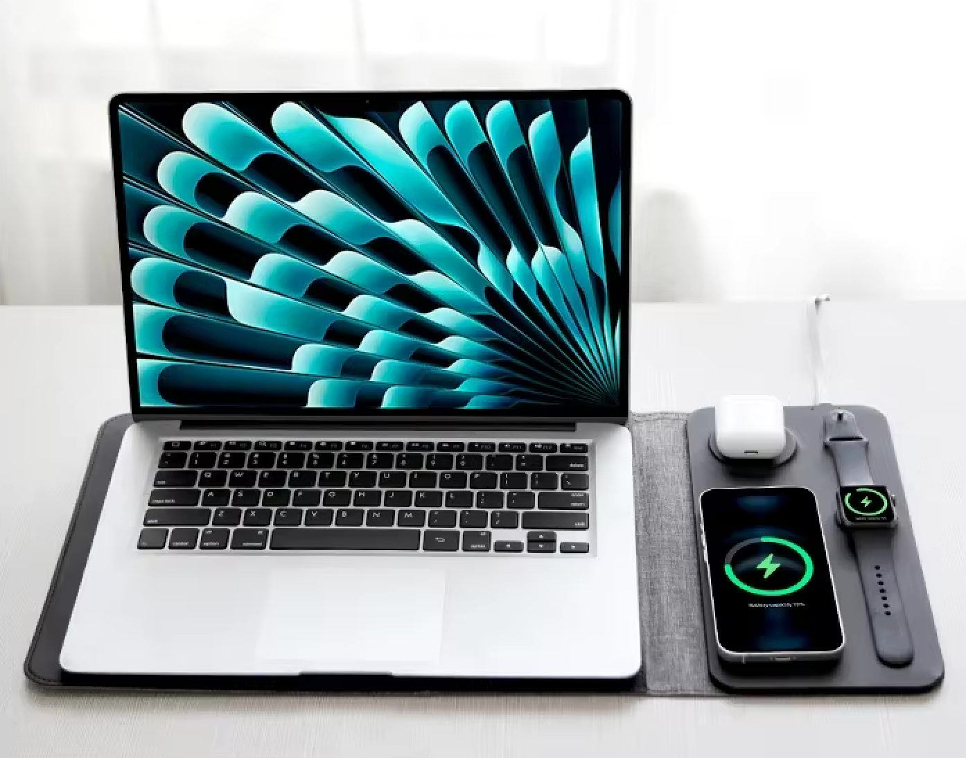 Open laptop with a colorful display on a white surface, accompanied by a smartphone and wireless mouse.