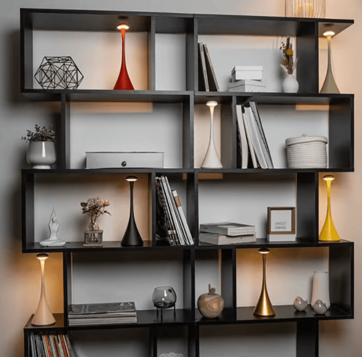 Black wall shelf with various decorative items against a neutral wall