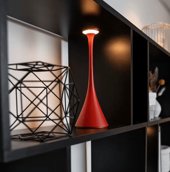 Red lamp on a shelf with geometric black lantern and blurred background