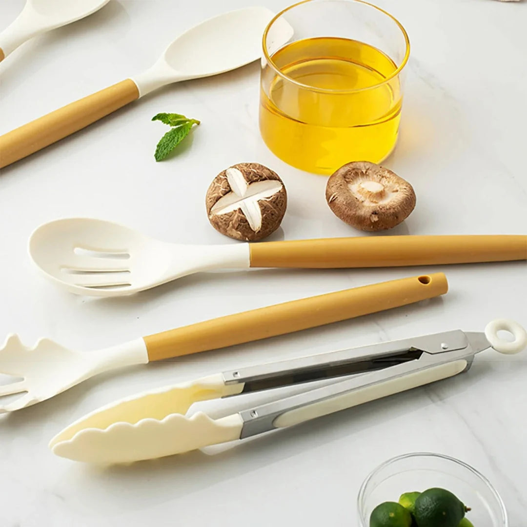 Set of kitchen utensils with yellow handles on a white surface with ingredients.