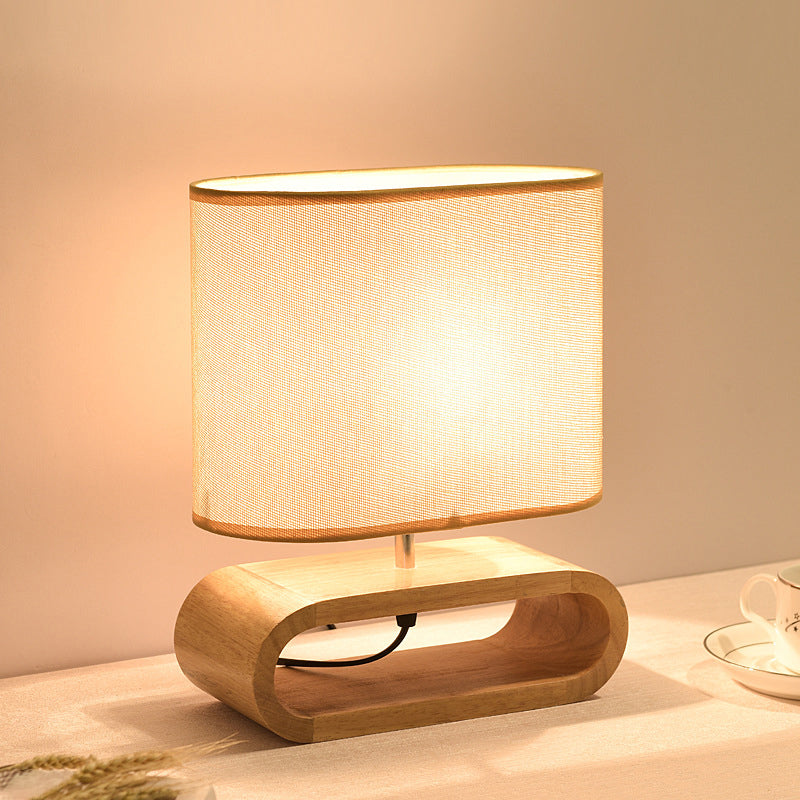 Wooden table lamp with a beige shade on a neutral background