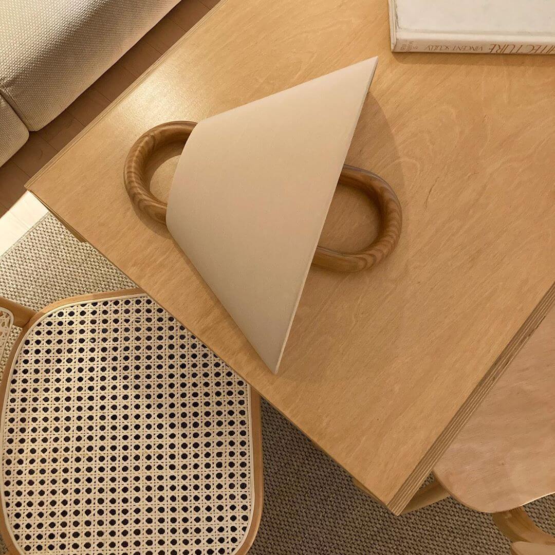 Wooden surface with a geometric object and woven mat