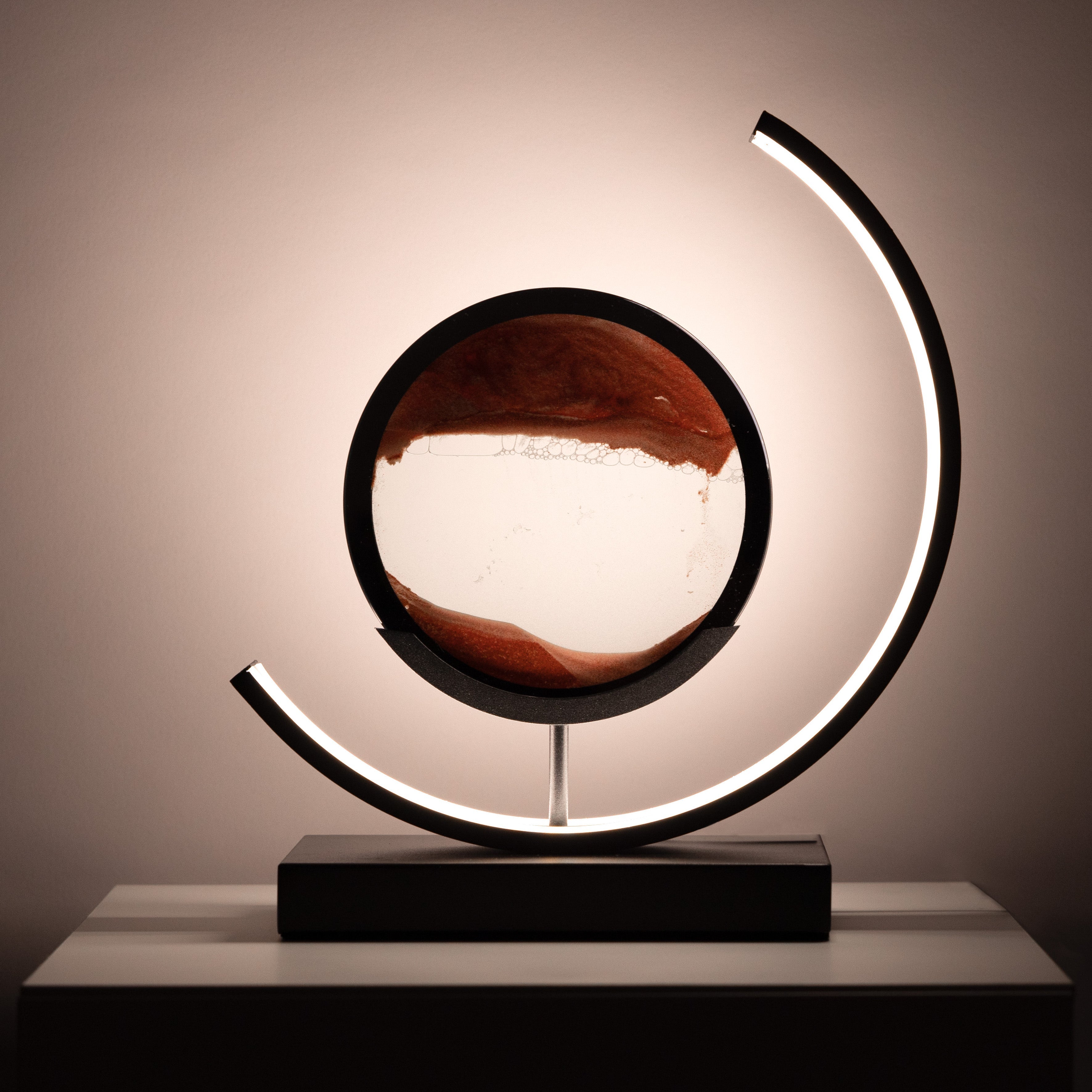 Decorative lamp with a circular design and a dark base on a neutral background