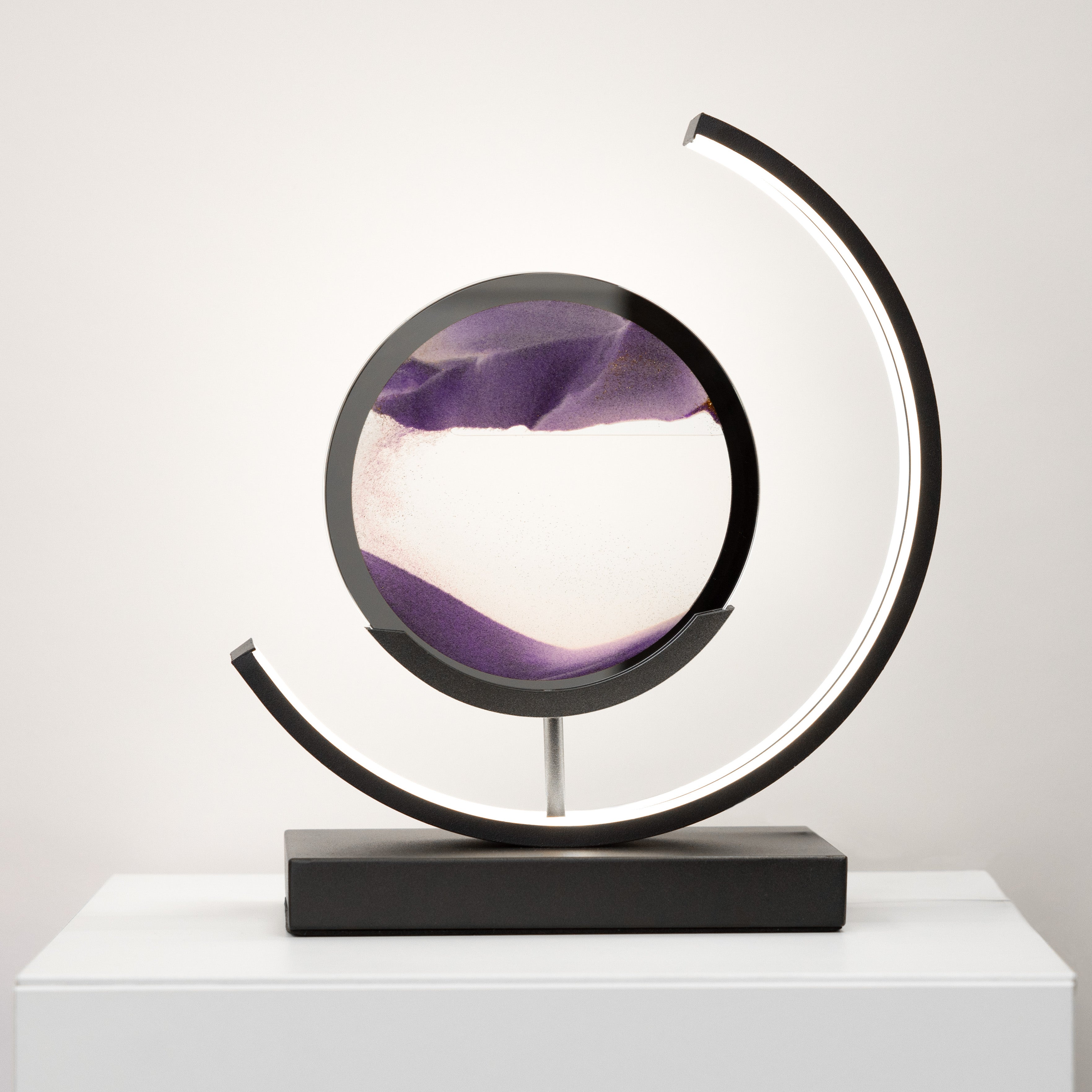 Decorative object with circular design and purple and white interior on a white surface.