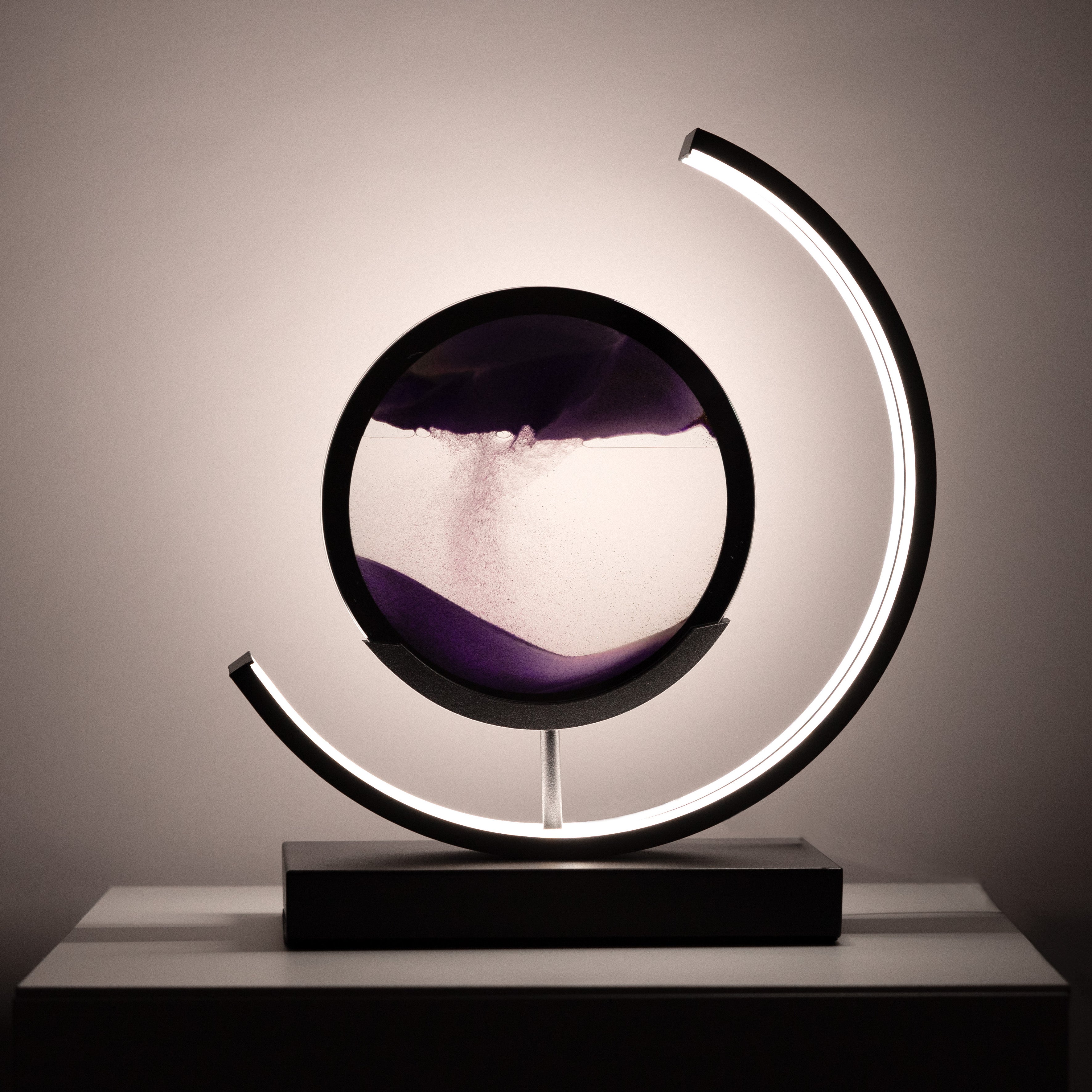 Modern table lamp with circular design and LED lighting on a neutral background