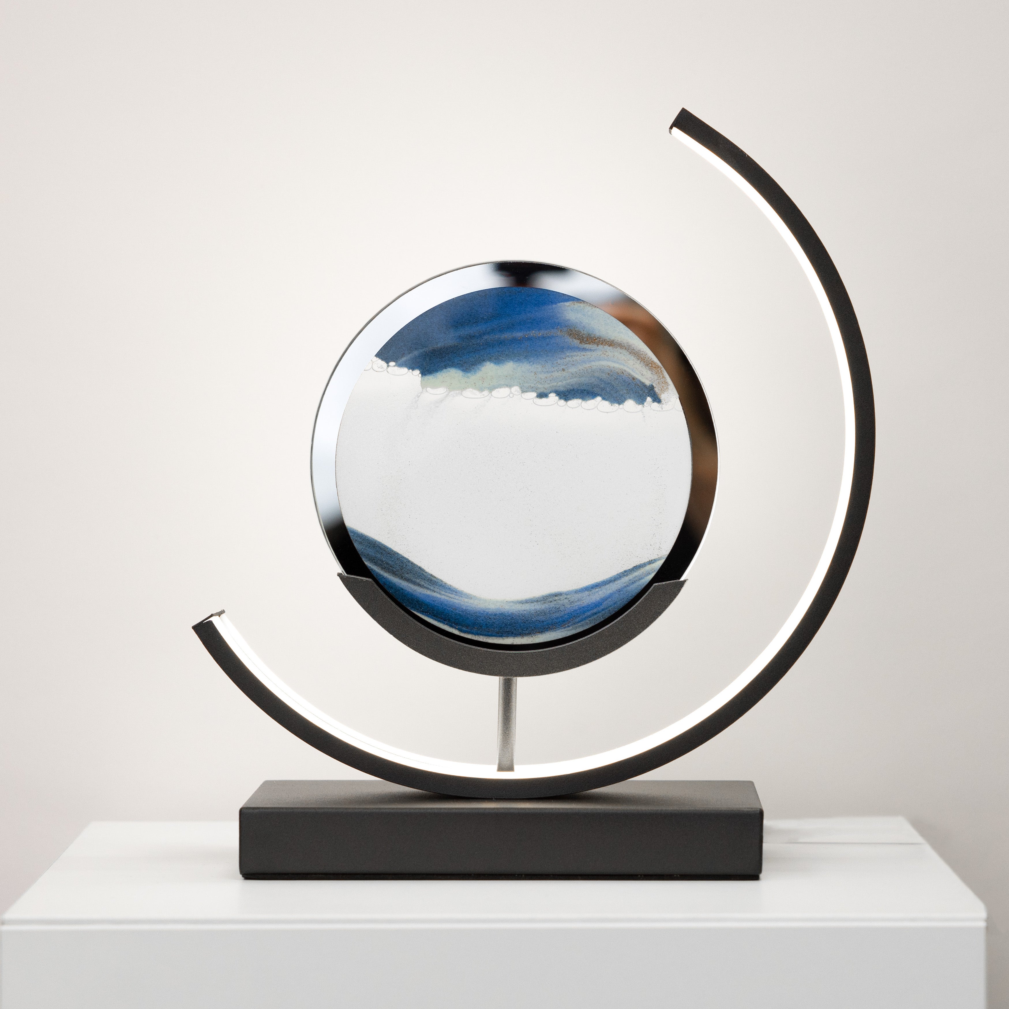 Decorative sphere with a circular base on a white surface