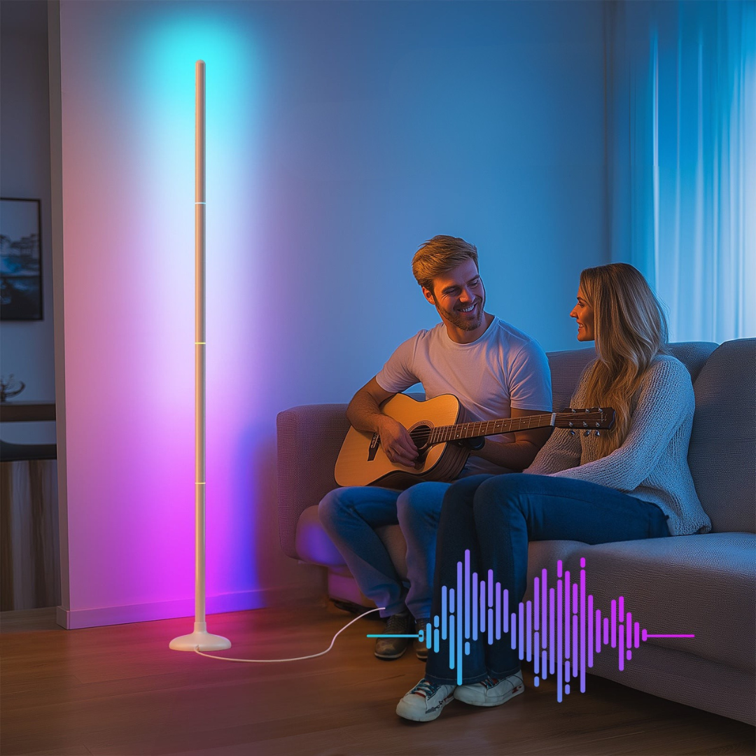 Two people sitting on a couch with a guitar, illuminated by a colorful floor lamp.