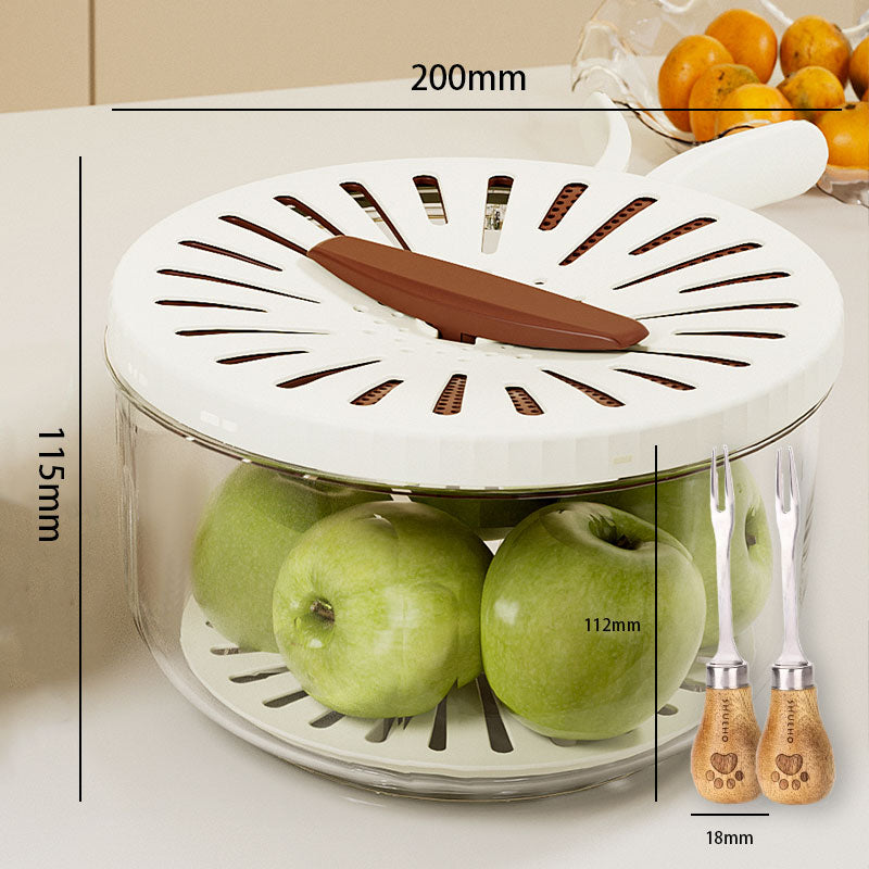 White kitchen tool with green apples inside, measurements indicated, and two wooden-handled knives on a white surface.