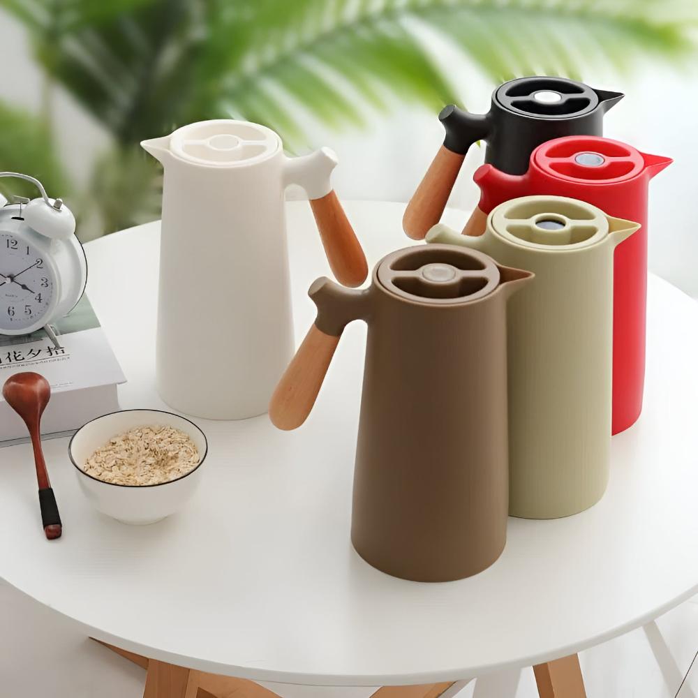 Set of colorful ceramic pots on a white table with a blurred green plant background