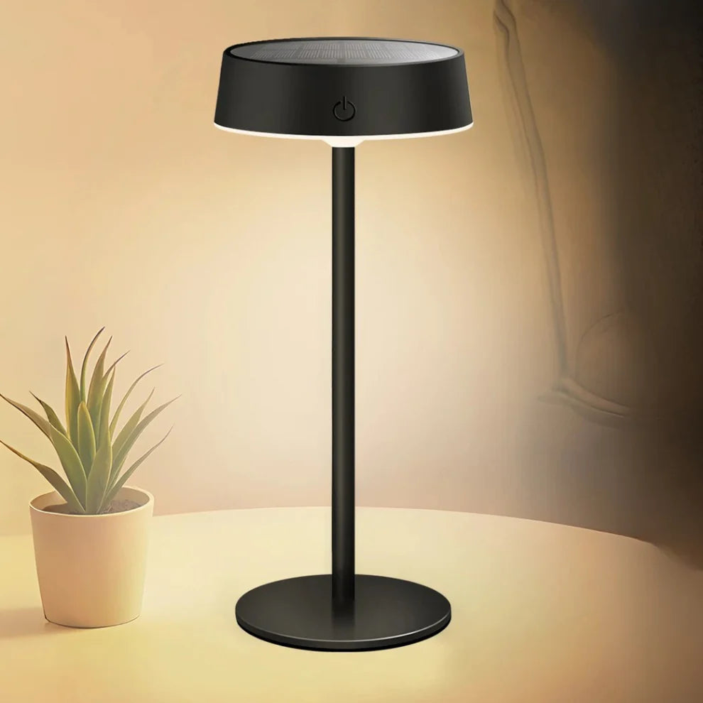 Black table lamp with a plant on a beige surface