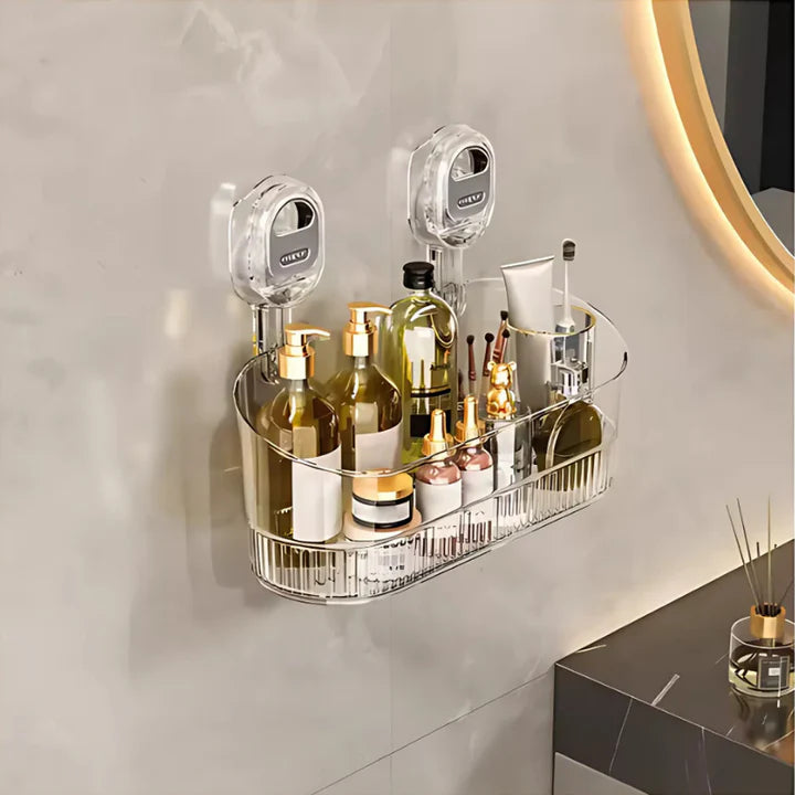 Clear wall-mounted caddy with bathroom products on a light gray wall.